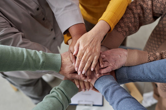 Close-up of five diverse hands stacked together in a show of unity and teamwork