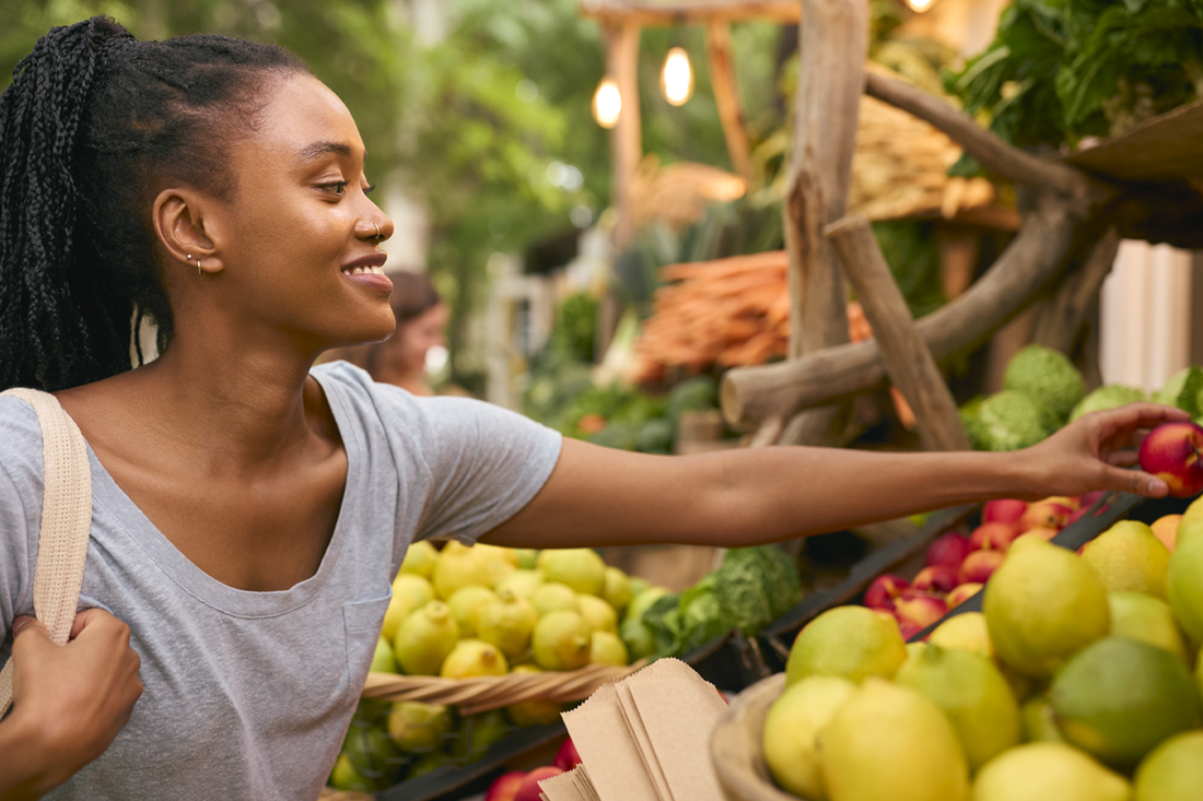 Woman reaching for produce at grocery store